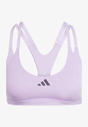 Lila sportinė liemenėlė su glotnia tekstūra, turinti plonas, kryžmines petnešas ir apvalų iškirpimą. Priekyje yra juodas logotipo akcentas.