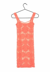 Coral lace dress, sleeveless, with intricate floral patterns and open weave texture. Hangs on a black hook for display.