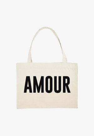 Borsa tote in tela color crema con la parola "AMOUR" stampata in grande in lettere nere in grassetto. Due manici resistenti per il trasporto.