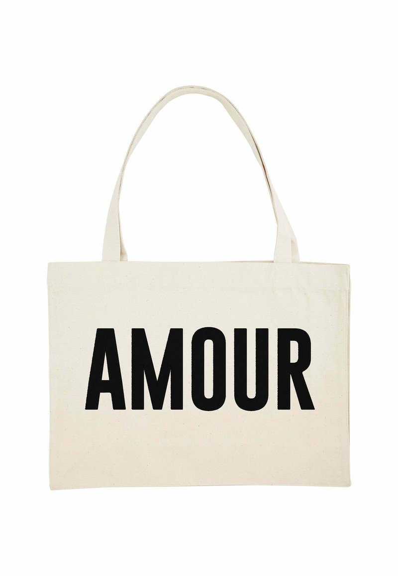 Stoffen tote bag in crème met het woord "AMOUR" prominent gedrukt in vette zwarte letters. Twee stevige handvatten voor het dragen.