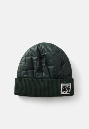 Grønn quiltet lue med ribbestrikket mansjett og logo-patch. Yttermaterialet er skinnende med en myk tekstur, som gir varme og stil.
