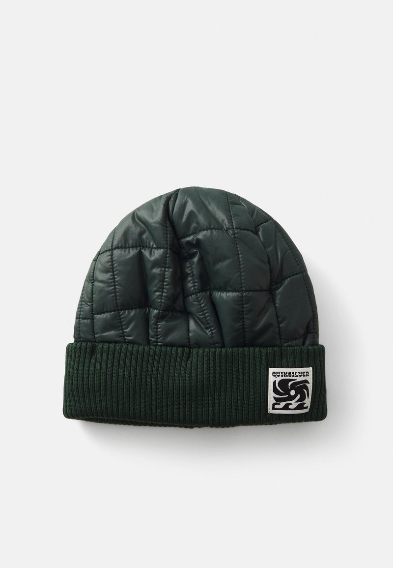 Grønn quiltet lue med ribbestrikket mansjett og logo-patch. Yttermaterialet er skinnende med en myk tekstur, som gir varme og stil.