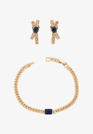 Arany karkötő téglalap alakú sötétkék kővel és hozzáillő arany fülbevalók kék ovális kövekkel és apró tiszta kristályokkal.