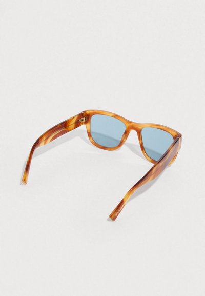 Γυαλιά ηλίου με ταρταρούγα σχέδιο και μπλε φακούς. Τετράγωνο σχήμα, γυαλιστερό φινίρισμα και ανθεκτικοί βραχίονες με διακριτική λεπτομέρεια επωνυμίας.