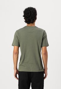 Olive green cotton t-shirt with a crew neck and short sleeves, featuring a smooth texture and minimal stitching details on the back.