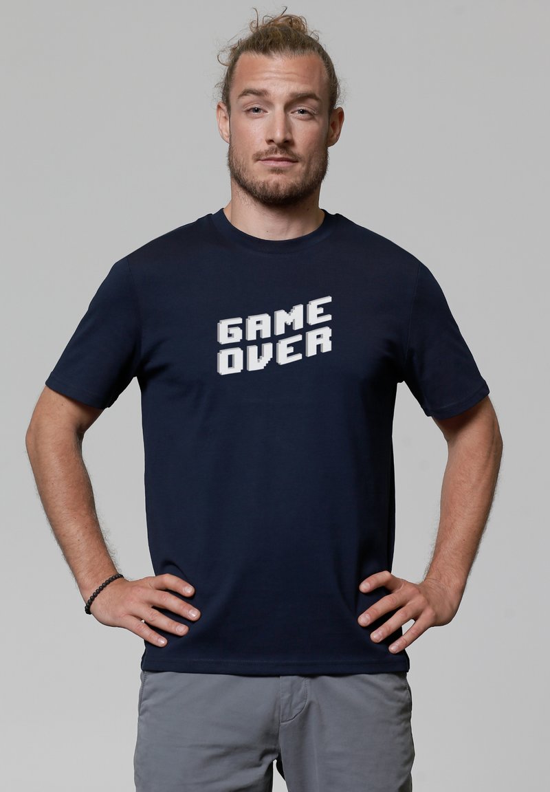 Navyblaue Baumwoll-T-Shirt mit einem pixelierten "GAME OVER" Grafik in Weiß auf der Vorderseite, Rundhalsausschnitt und kurzen Ärmeln.