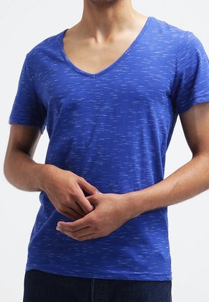 T-shirt bleu à manches courtes avec un col en V profond. Le tissu présente un motif texturé subtil avec des stries bleu clair réparties sur l'ensemble.