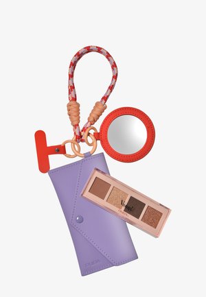 Borsetta in pelle viola con chiusura a scatto, abbinata a una palette di ombretti in una custodia trasparente e a uno specchio rotondo con bordo e cinturino rossi.