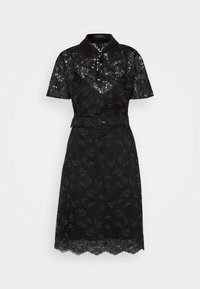 Robe en dentelle noire avec col, manches courtes, motif floral, taille ceinturée et ourlet festonné. Présente une superposition transparente pour ajouter de la texture.