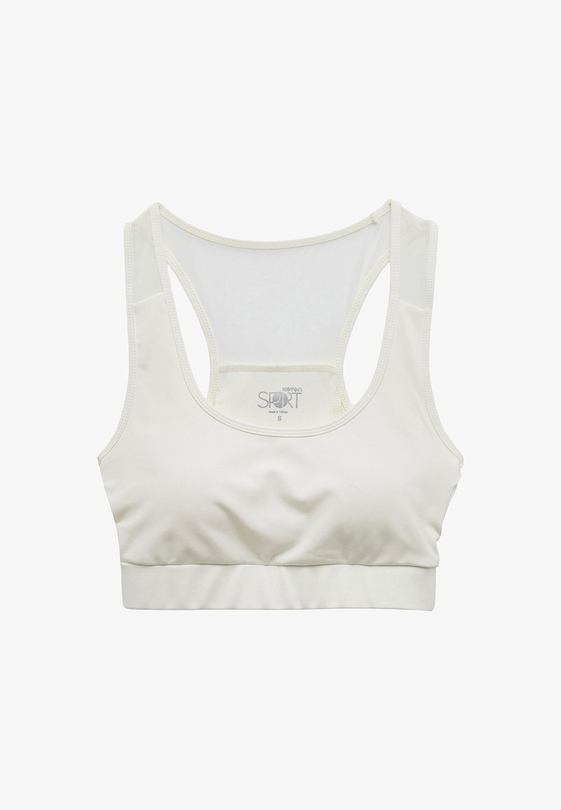 Ljus beige sport-bh i slät tyg, med racerback-design, stretchigt band och minimala sömnadsdetaljer för komfort.