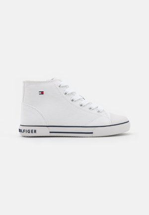 Zapatilla blanca de lona alta con cordones blancos, suela de goma, rayas azules y pequeño logo de Tommy Hilfiger en rojo, blanco y azul en el lateral.