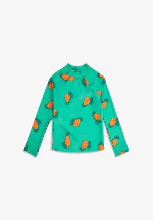 Tirkizna košulja dugih rukava s visokim ovratnikom, ukrašena ponavljajućim narančastim licima mrkve sa zelenim listovima na vrhu.