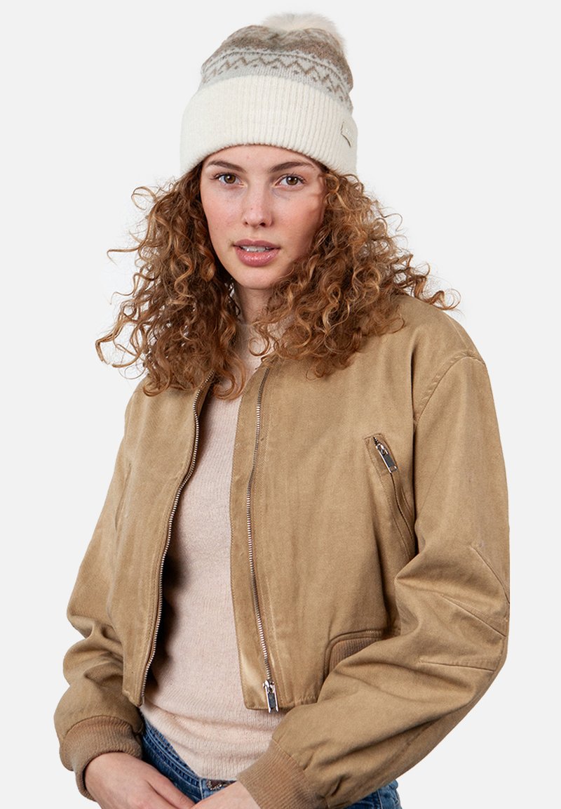 Bruine, cropped bomberjack gemaakt van zachte suede, met een ritssluiting aan de voorkant en zijzakken, gecombineerd met een crèmekleurige gebreide beanie met een pompon.