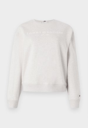 Jasnoszara bluza z miękkiego materiału. Posiada okrągły dekolt, długie rękawy i skrócony dół. Na przodzie nadrukowane logo.