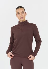 Pitkähihainen urheilu-toppi tummassa burgundin värissä, jossa on neljänneksen vetoketjukolari, teksturoitu kangas ja slim fit -malli. Koristeltu huomaamattomalla logolla.