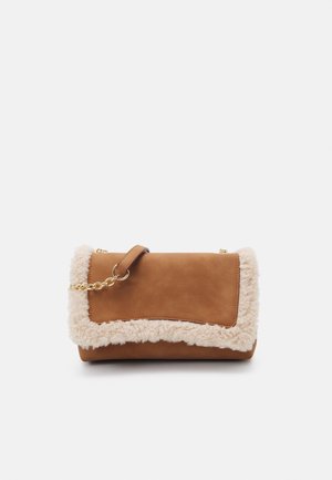 Pochette en cuir marron avec bordure en peau lainée crème et une chaîne dorée contre un fond blanc.