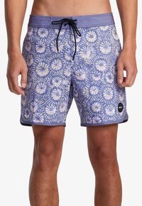 Bañadores para hombre en color púrpura claro con un patrón floral. Cuentan con una cintura ajustable con cordón y una etiqueta de marca negra en el lado izquierdo.
