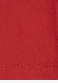 Piros pamutvászon sima textúrával. Az alján gondosan, dupla varrással készült szegéssel rendelkezik. Egyenletes szín mindenhol.