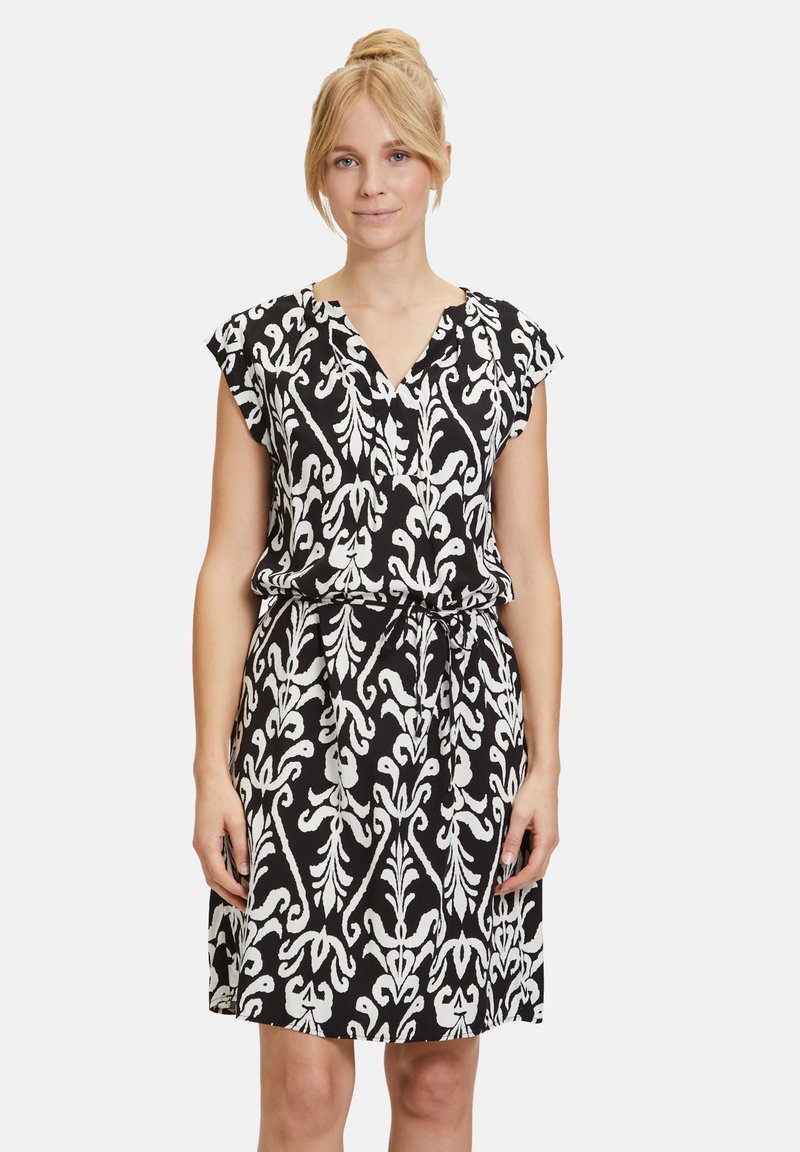 Schwarz-weiß gemustertes Kleid mit kurzen Ärmeln, V-Ausschnitt, verstellbarem Taillenzug und einem entspannten Schnitt.