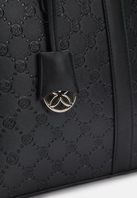 Borsa nera strutturata in tessuto con motivo in rilievo del logo, dettagli in pelle e una chiusura circolare dorata. Presenta un design rigido.