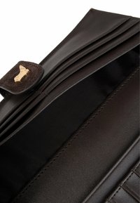 Bruine leren portemonnee met een gestructureerde afwerking, voorzien van meerdere kaarthouders, een gouden sluiting en een gladde binnenvoering.