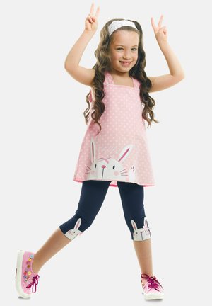Túnica rosa con lunares y estampado de conejitos, combinada con leggings navy que tienen detalles de conejitos. Zapatillas brillantes completan el conjunto.