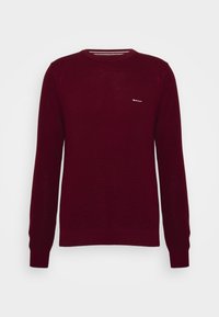 Bordeaux gebreide trui met ronde hals, lange mouwen, ribgebreide manchetten en een subtiele logo op de borst. Gevoegd patroon over het hele kledingstuk.
