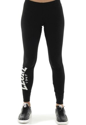 Modèle portant un legging noir avec l’inscription blanche « LEONE 1947 » et des baskets noires sur fond blanc.