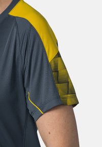 Maglietta sportiva a maniche corte di colore grigio scuro con una sezione nelle spalle di un brillante giallo, dotata di un motivo a griglia e dettagli testurizzati.
