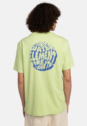 Hellgrünes Baumwoll-T-Shirt mit einem großen blauen Grafikdesign, das die Wörter "WIND", "WASSER", "ELEMENT", "FEUER" und "ERDE" in einem kreisförmigen Arrangement zeigt.