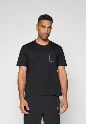 Svart t-skjorte med kort erm laget av bomull, med en firkantet lomme med en subtil glans. Designet er enkelt og moderne.