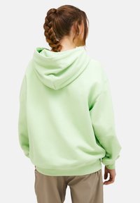 Felpa oversized verde chiaro con cappuccio regolabile, polsini e orlo a costine, caratterizzata da una texture liscia e un design casual.