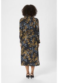 Abito midi floreale con maniche lunghe, in tessuto nero con fiori gialli e blu, vita adatta e spacco laterale.