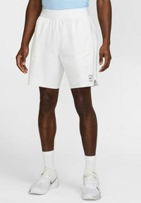 Pantaloni sportivi bianchi con un elastico in vita, tasche laterali e un piccolo logo grafico in basso a sinistra. Materiale liscio e leggero.