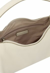 Sac à main en cuir beige avec un extérieur texturé, doté d'une doublure crème et d'une poche intérieure zippée. Design avec un bord supérieur incurvé.