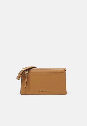 Lichtbruine leren Michael Kors polstasje met gouden rits en verstelbare band op een witte achtergrond.
