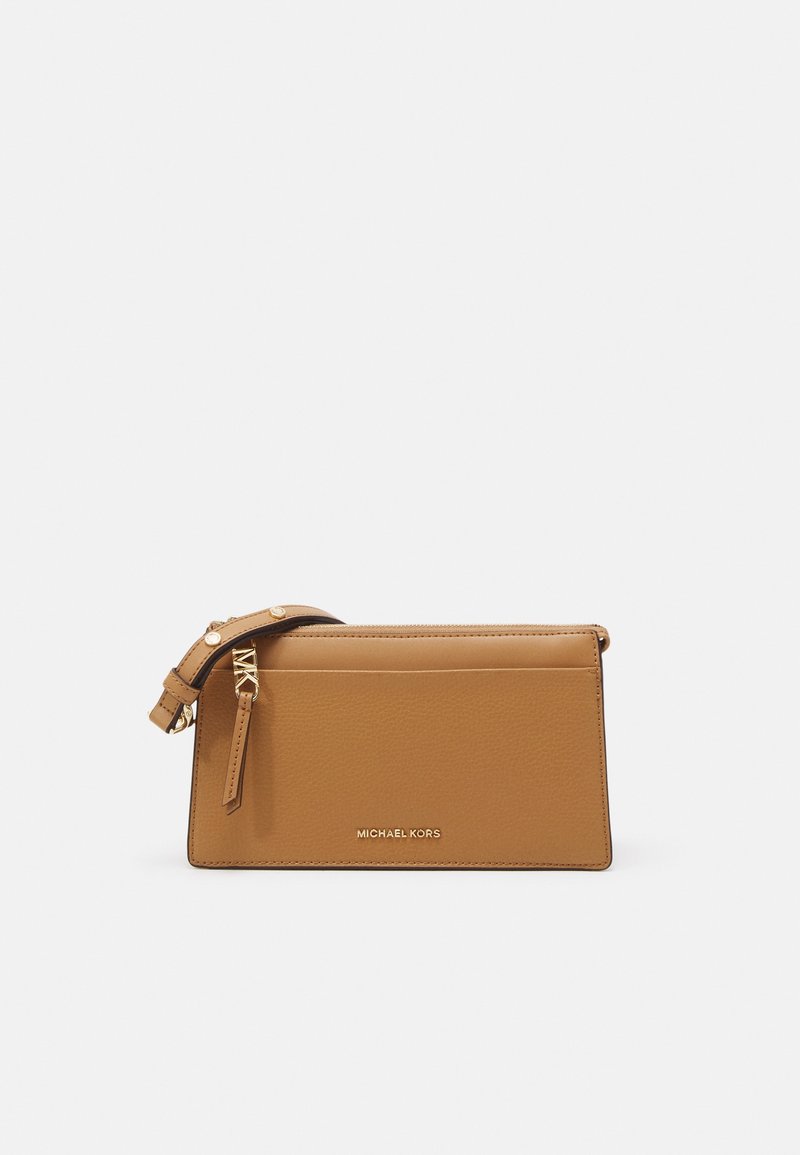 Pochette bracelet Michael Kors en cuir fauve avec fermeture éclair dorée et sangle ajustable sur fond blanc.