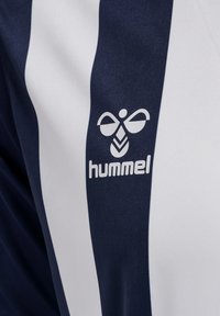 Stof met verticale strepen in marineblauw en wit met een wit hummel-logo met een gestileerde bij op een marineblauwe streep.
