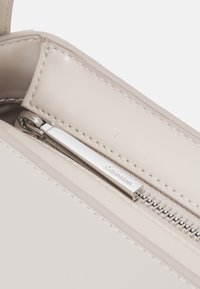 Calvin Klein REFINED SCULPT BAG SHINY - Bolso de mano - gray morn