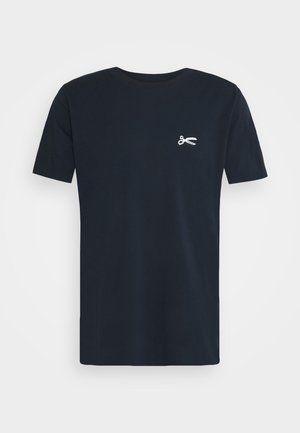 Czarny t-shirt z krótkim rękawem i okrągłym dekoltem, z małą grafiką białych nożyczek na lewej piersi, przedstawiony na jednolitym tle.