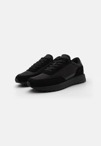 Zwarte sneakers gemaakt van een mix van gladde stof en suède, met een vetersluiting, ronde neus en een gegoten rubberen zool.