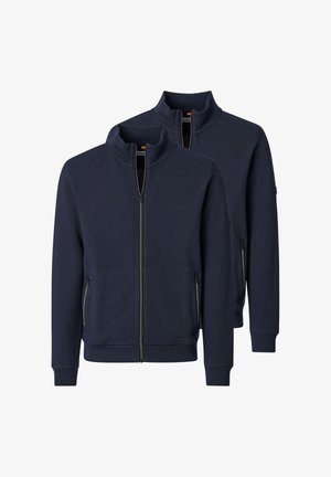 Dwie granatowe kurtki na pełny zamek z kołnierzem typu stójka i zapinanymi na zamek kieszeniami bocznymi, przedstawione na białym tle.