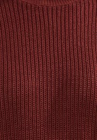 Sweter z dzianiny w głębokim czerwonym kolorze o ryflowanej fakturze. Posiada okrągły dekolt i jednolite pionowe wzory w całej konstrukcji.