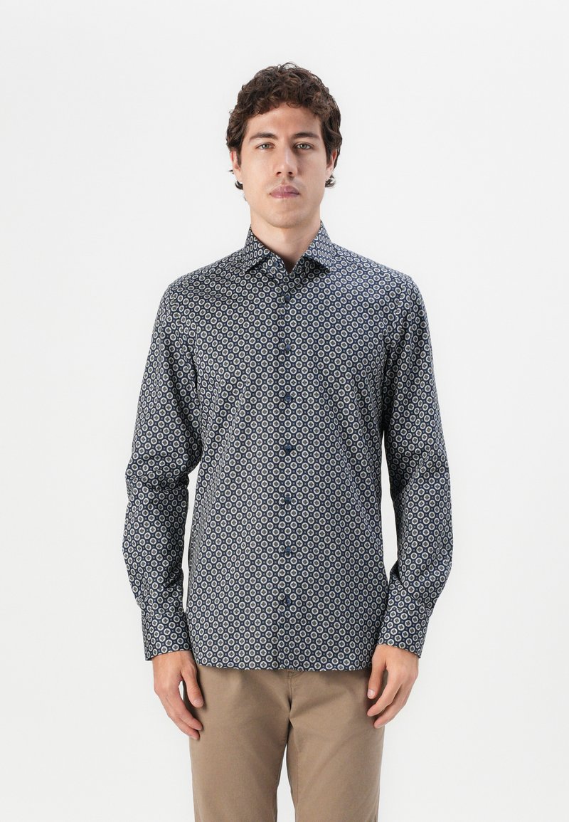 Navy button-up shirt featuring a geometric pattern in white and light blue. Long sleeves with button cuffs, tailored fit, smooth fabric texture.