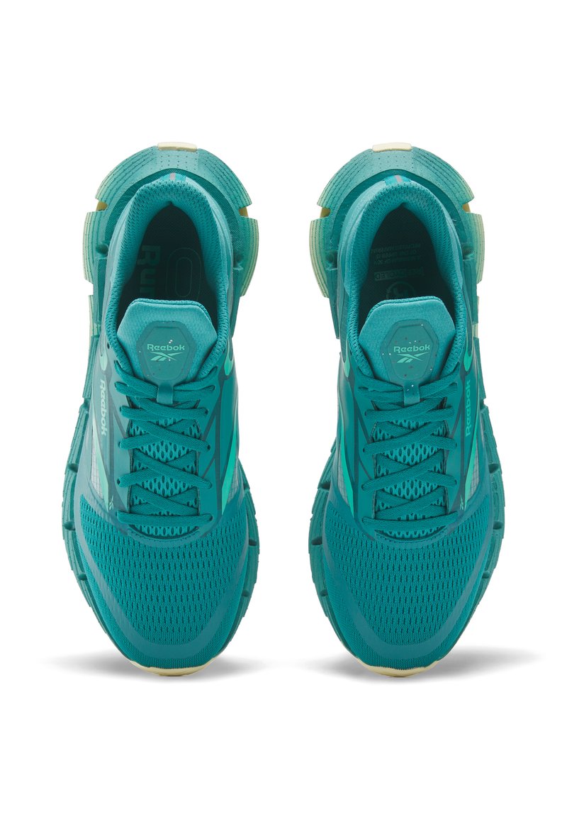 Zapatillas de running en azul verdoso con parte superior de malla, suela texturizada y diseño de cordones. Presenta el logo de Reebok y acentos reflectantes en los laterales.