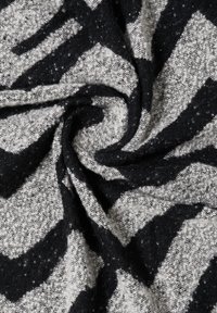 Svart och vit hoodie i tyg med en texturerad väv, med ett zigzagmönster och en mjuk, något fluffig yta. Cirkulär form.