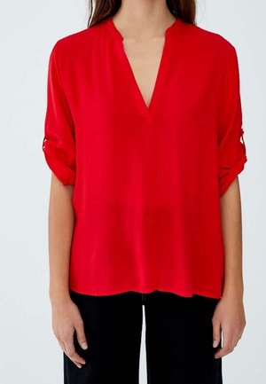 Rode, lichte blouse met een V-hals en opgerolde mouwen. Gladde textuur, losse pasvorm en een afgeronde zoom.