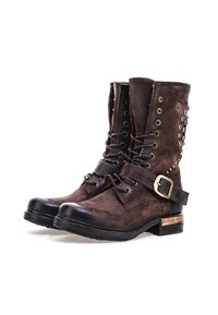 Tamnosmeđe kožne čizme sa vezanjem, trakama s kopčanjem, dekorativnim metalnim zakovicama i niskim potpeticama, prikazane jedna uz drugu na bijeloj pozadini.