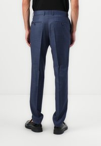Pantalones de cuadros azules para hombre con un ajuste entallado, que presentan bolsillos traseros dobles con botones negros y una textura de tela suave.
