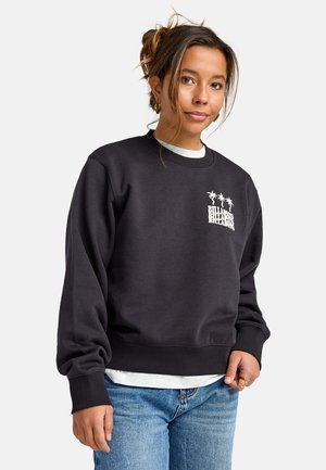 Zwarte crewneck sweatshirt gemaakt van zachte stof, met een palmboomafbeelding in het wit. Geribbelde boorden en onderrand, gelaagd over een wit T-shirt.